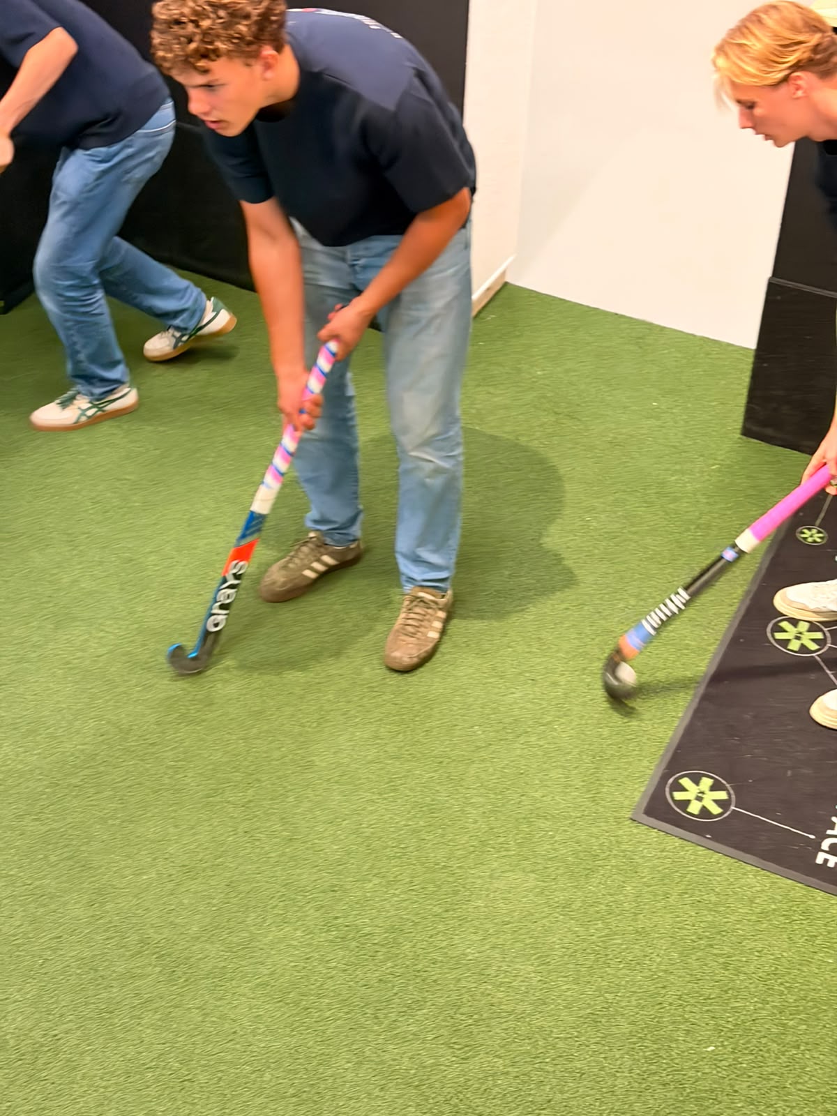 Twee spelers vergelijken hockeysticks op het testveld
